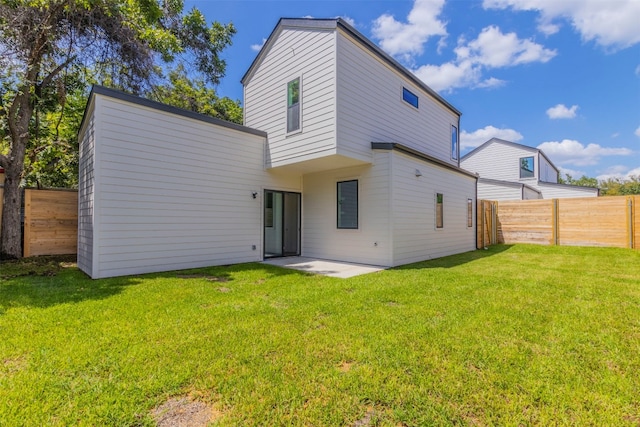 rear view of property with a lawn and a patio