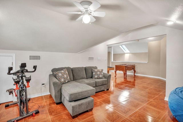 living room with vaulted ceiling with skylight, ceiling fan, and tile patterned floors