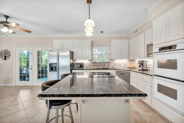 kitchen with a kitchen island, a kitchen breakfast bar, appliances with stainless steel finishes, and a healthy amount of sunlight