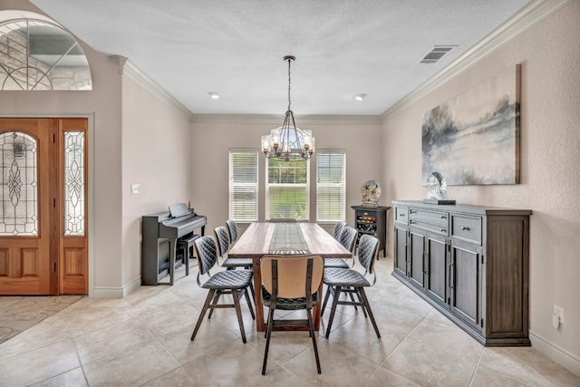 dining room featuring a chandelier, a textured ceiling, and ornamental molding