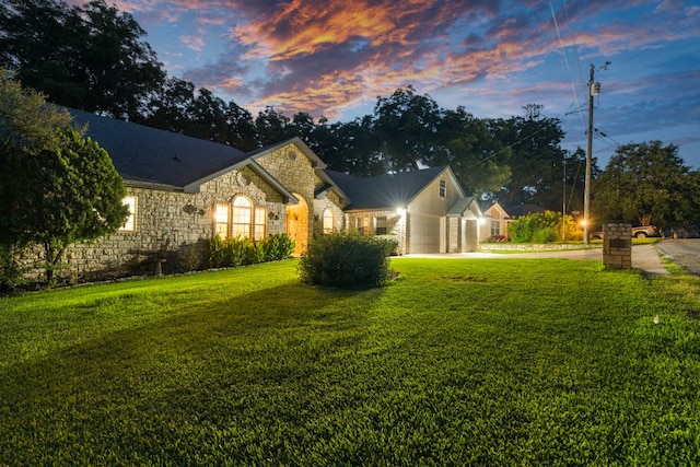 view of front of house featuring a garage and a lawn