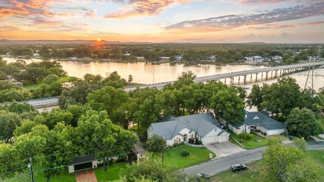 aerial view at dusk featuring a water view