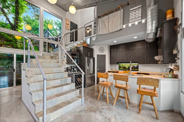 stairway with concrete floors and a high ceiling