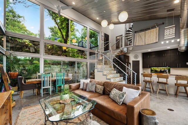 3025 Geronimo Trl, Austin, TX 78734 - living room with finished concrete flooring, a high ceiling, and stairs