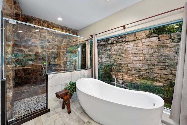 3025 Geronimo Trl, Austin, TX 78734 - bathroom featuring a freestanding bath, a shower stall, tile walls, and marble finish flooring
