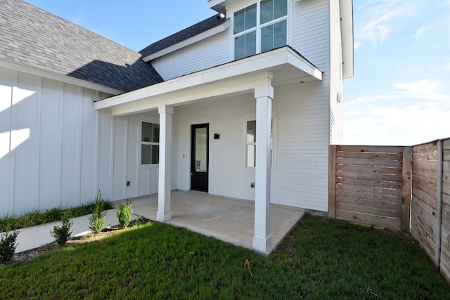 view of exterior entry featuring a patio area and a yard