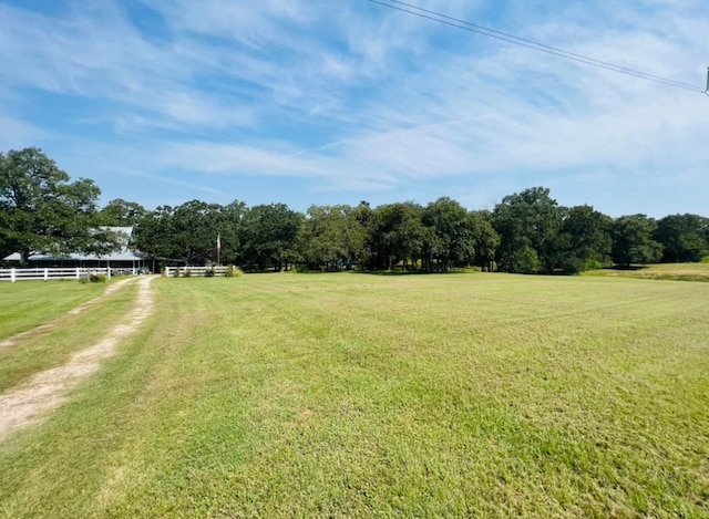 view of yard with fence and a rural view