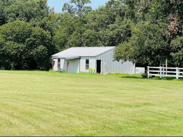 view of yard with an outbuilding, a pole building, and fence