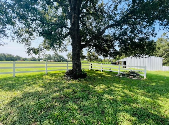 view of yard with an outdoor structure and a rural view