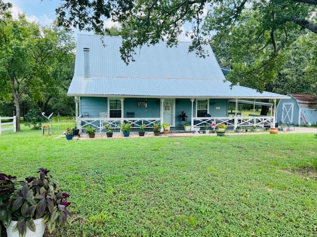 view of front facade featuring a front yard and a storage shed