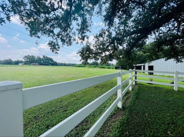 view of yard with fence and a rural view