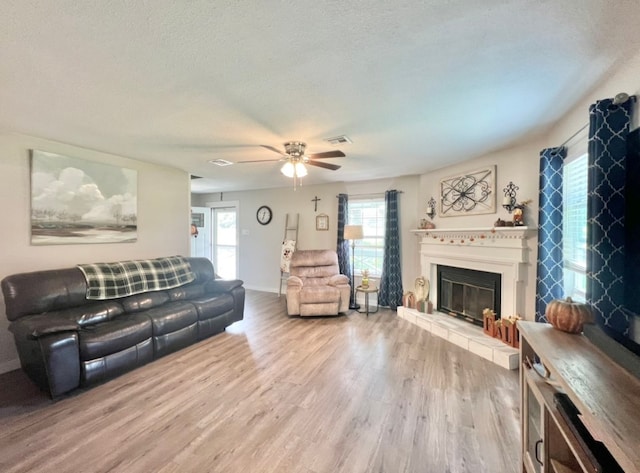 living room featuring hardwood / wood-style floors, a textured ceiling, and ceiling fan