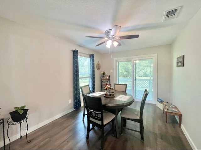 dining room with a textured ceiling, dark hardwood / wood-style flooring, ceiling fan, and a healthy amount of sunlight