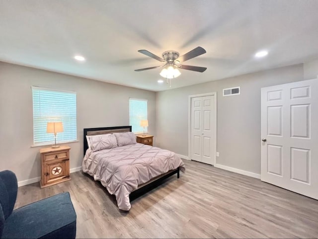 bedroom with a ceiling fan, baseboards, visible vents, and wood finished floors