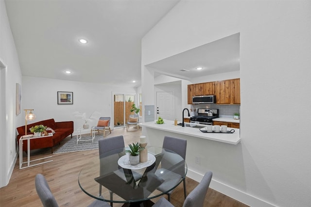 dining area featuring light wood-type flooring and sink