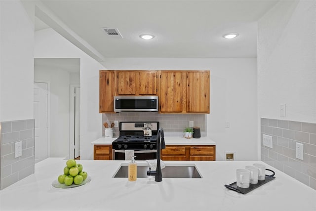 kitchen featuring stainless steel appliances, sink, and tasteful backsplash