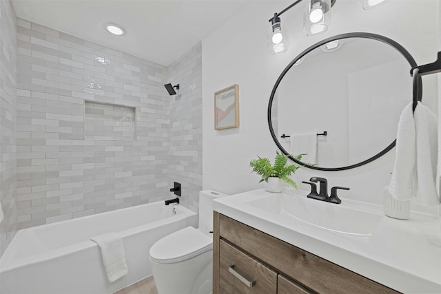 full bathroom with vanity, tiled shower / bath combo, and toilet