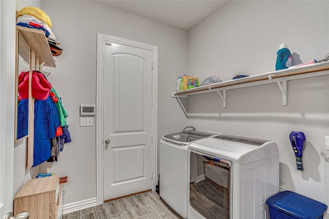 clothes washing area featuring light hardwood / wood-style flooring and washer and clothes dryer