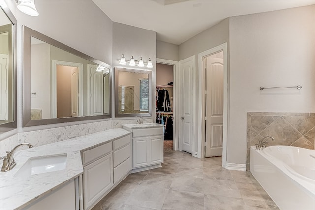 bathroom with dual vanity, a bath, and tile patterned floors