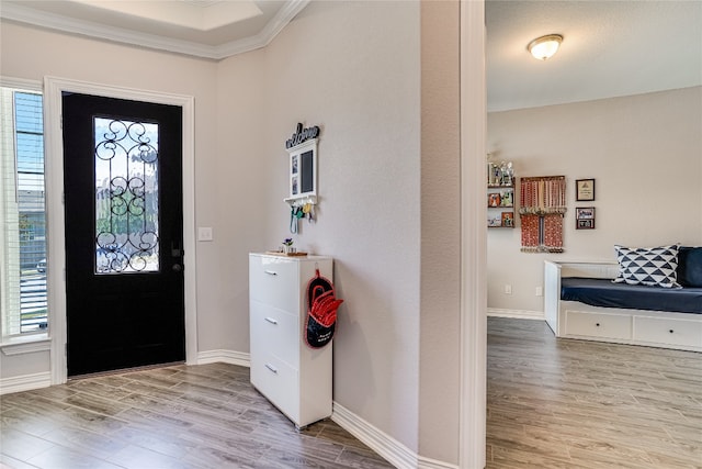 entryway with plenty of natural light, crown molding, and hardwood / wood-style floors