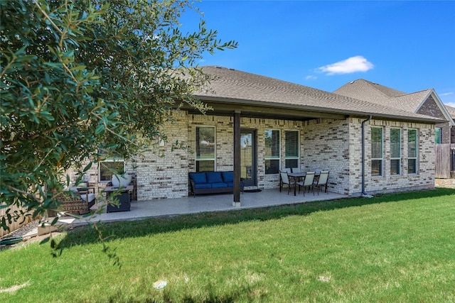 rear view of house with an outdoor living space, a patio, and a lawn