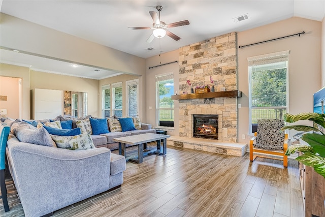 living room featuring ceiling fan, a fireplace, plenty of natural light, and light hardwood / wood-style floors