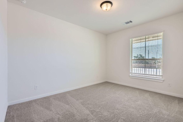 carpeted empty room with visible vents and baseboards