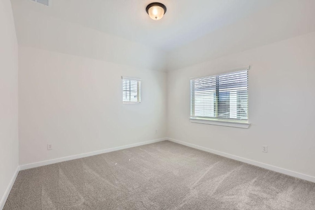 carpeted empty room with baseboards