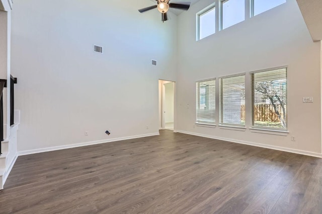 unfurnished living room with visible vents, baseboards, dark wood-type flooring, and ceiling fan