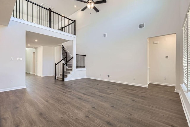 unfurnished living room featuring visible vents, baseboards, dark wood finished floors, stairway, and a ceiling fan