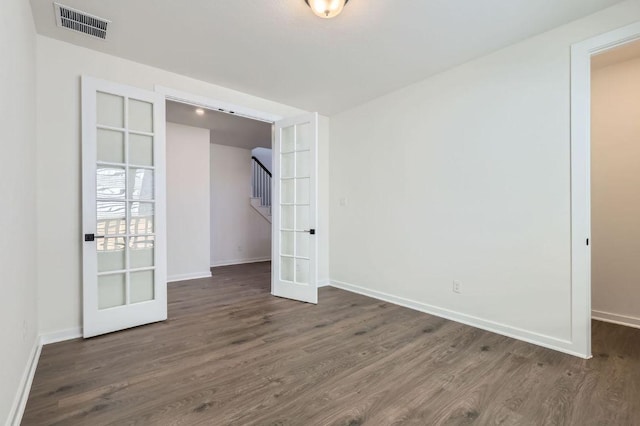 unfurnished bedroom with dark wood-style floors, french doors, visible vents, and baseboards