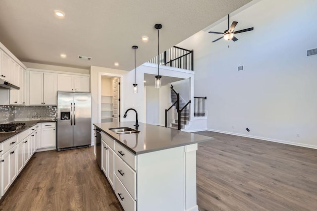 kitchen featuring dark countertops, visible vents, stainless steel appliances, a ceiling fan, and a sink