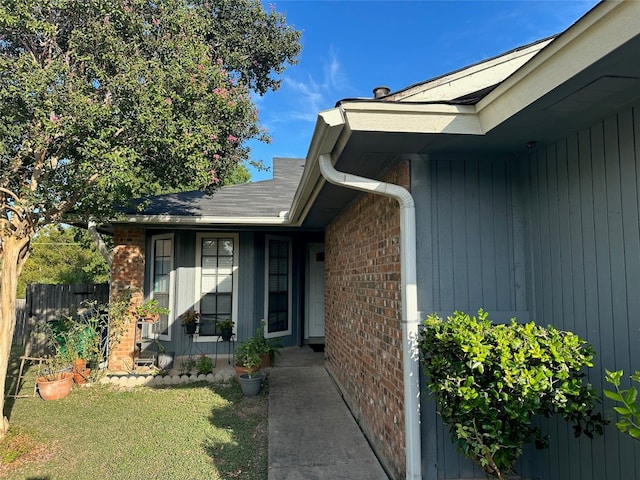 view of exterior entry with a lawn