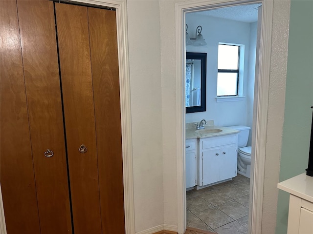 bathroom featuring tile patterned floors, vanity, and toilet