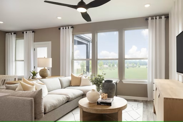 living room with light hardwood / wood-style flooring and ceiling fan