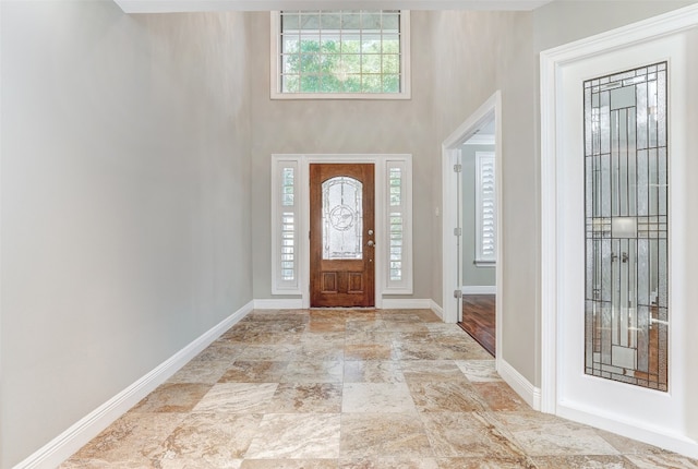 entrance foyer featuring a towering ceiling and light tile patterned floors