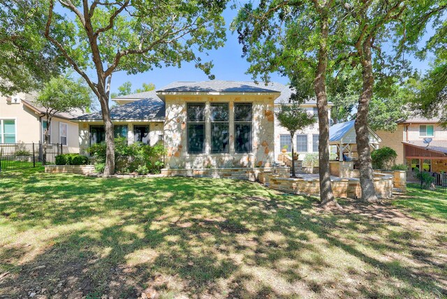 rear view of property featuring a lawn