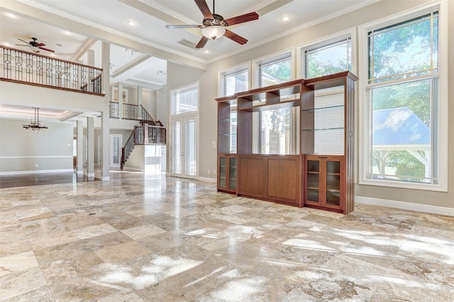 interior space with a wealth of natural light, ceiling fan, a high ceiling, and ornamental molding