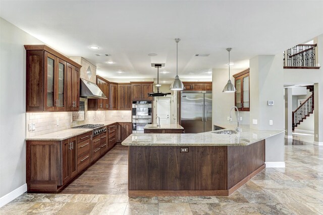 kitchen featuring sink, appliances with stainless steel finishes, light hardwood / wood-style flooring, decorative backsplash, and kitchen peninsula