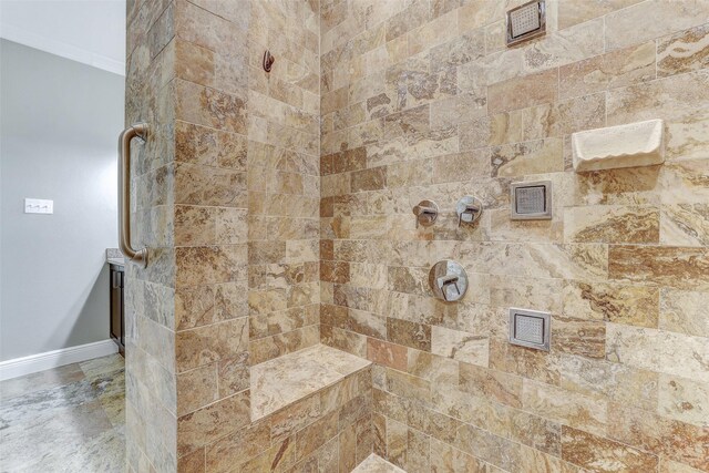 bathroom with tiled shower and crown molding