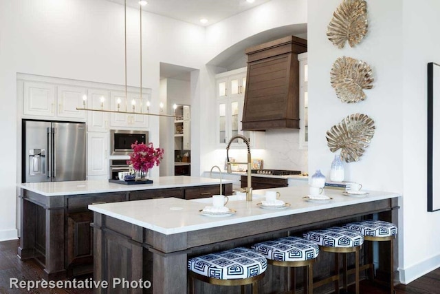 kitchen with decorative light fixtures, stainless steel appliances, dark hardwood / wood-style flooring, and white cabinets