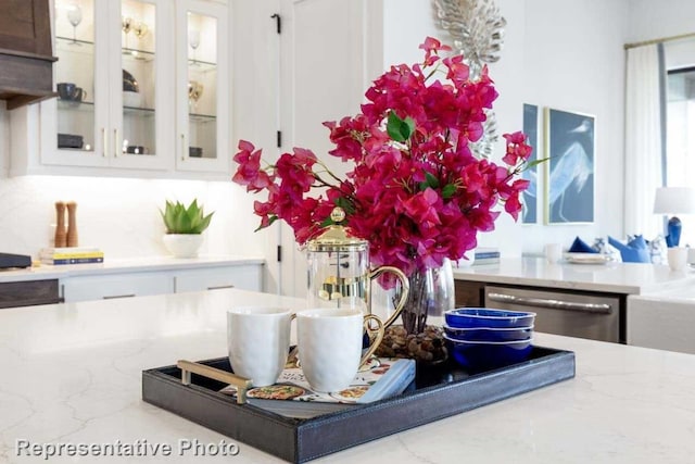 room details featuring white cabinetry, dishwasher, and tasteful backsplash