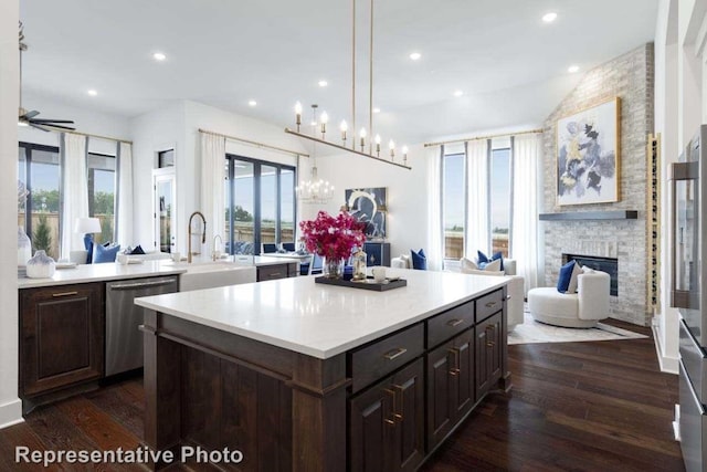 kitchen with an island with sink, a wealth of natural light, dark hardwood / wood-style floors, and dishwasher