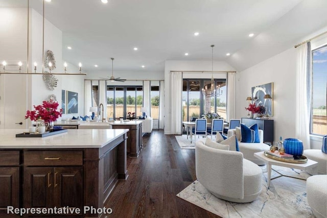 kitchen with ceiling fan, lofted ceiling, hanging light fixtures, sink, and dark wood-type flooring