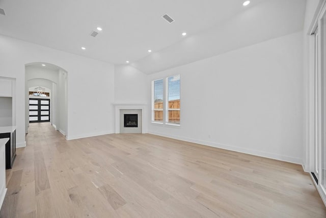 unfurnished living room with lofted ceiling and light hardwood / wood-style floors