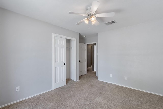 unfurnished bedroom with ceiling fan, carpet, and a closet