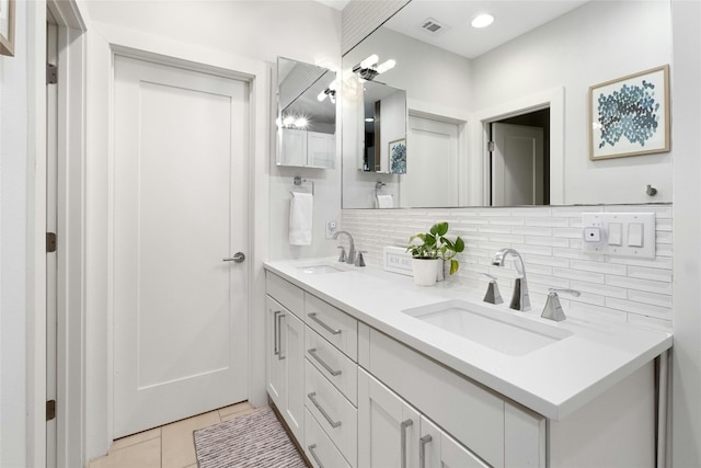 bathroom with tile patterned flooring, backsplash, and dual vanity