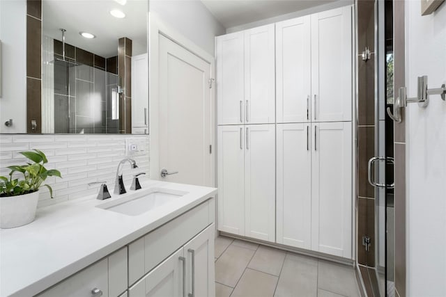 bathroom featuring backsplash, an enclosed shower, vanity, and tile patterned floors