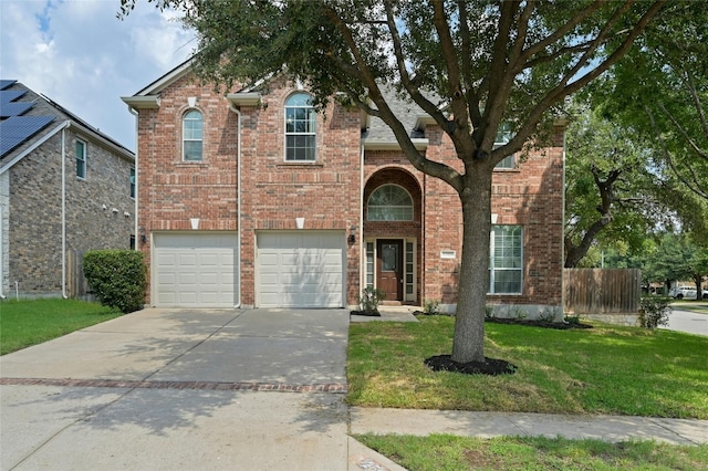 traditional-style home featuring fence, concrete driveway, an attached garage, a front yard, and brick siding