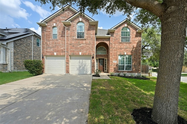 traditional home with brick siding, an attached garage, concrete driveway, and a front lawn